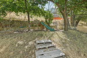 Fenced backyard featuring a playground