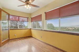 Unfurnished sunroom featuring wood finished floors and baseboards