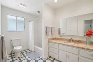 Bathroom featuring vanity, shower / bathtub combination with curtain, and tile patterned floors