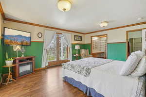 Bedroom with wood finished floors and crown molding and French doors to balcony