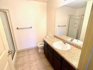 Three quarter bathroom featuring a shower stall and vanity