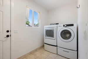 Laundry area featuring independent washer and dryer and light tile patterned floors