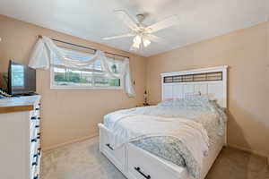 Bedroom with light colored carpet and ceiling fan