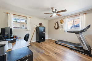Office area with ceiling fan, plenty of natural light, and wood finished floors