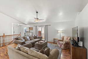 Living area with lofted ceiling, ceiling fan, and wood finished floors