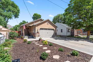 Ranch-style house featuring an attached garage, stucco siding, concrete driveway, and stone siding