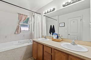 Bathroom with a garden tub, double vanity, curtained shower, and tile patterned flooring