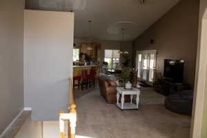 Living area featuring lofted ceiling and carpet flooring