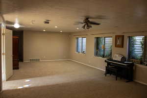 Unfurnished living room with ceiling fan, a textured ceiling, carpet floors, and recessed lighting
