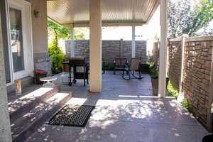 Fenced backyard with a patio area and grilling area
