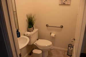 Half bath featuring baseboards and tile patterned floors