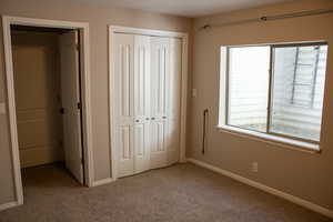 Unfurnished bedroom featuring a closet and light carpet