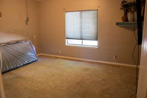 Unfurnished bedroom with carpet floors and baseboards