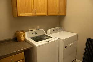 Washroom featuring cabinet space and washer and dryer