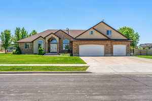 View of front of house featuring driveway, an attached garage, and brick siding
