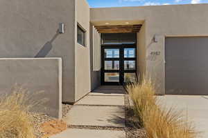 Entrance to property featuring stucco siding and french doors