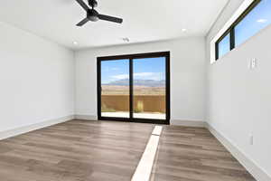 Spare room with ceiling fan, recessed lighting, wood finished floors, and a mountain view