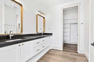 Bathroom with double vanity and wood finished floors