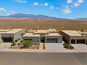 View of front of home with a mountain view, stucco siding, and driveway