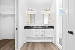 Full bathroom with wood finished floors and double vanity