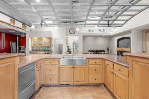 Kitchen with light brown cabinets, dishwasher, open floor plan, and a warming drawer