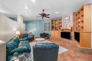 Living area featuring built in features and a ceiling fan