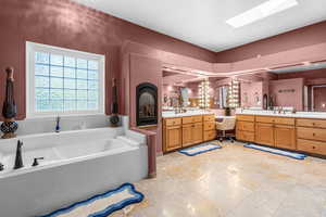 Full bathroom featuring vanity, a bath, and a skylight