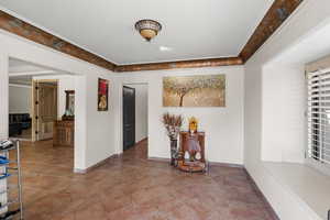 Hallway featuring crown molding and tile patterned flooring