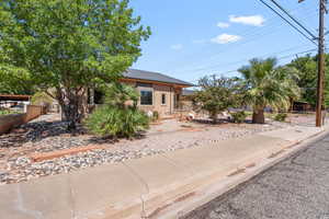 View of property hidden behind natural elements featuring a metal roof
