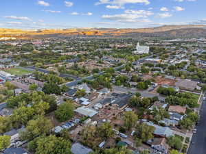 Aerial view of property and surrounding area featuring a mountain backdrop and nearby suburban area