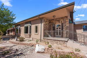View of front facade featuring stone siding and stucco siding