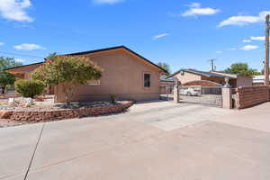 View of side of home with a gate and driveway