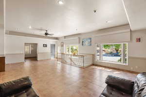 Living area with a ceiling fan, recessed lighting, and light tile patterned floors