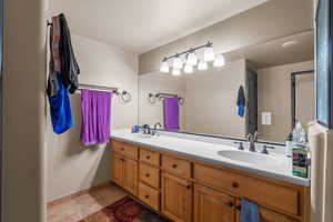 Full bathroom with double vanity and baseboards