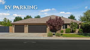 View of front facade featuring a garage, driveway, stucco siding, and a tiled roof