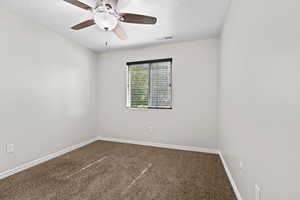 Carpeted empty room with baseboards and ceiling fan