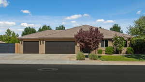 View of front of house featuring concrete driveway, an attached garage, stucco siding, and a tiled roof