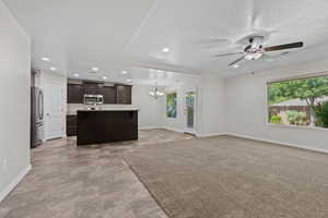Unfurnished living room featuring a chandelier, recessed lighting, and a ceiling fan