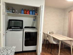 Laundry area featuring independent washer and dryer and wood finished floors