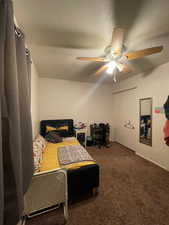 Bedroom with carpet, ceiling fan, and a textured ceiling