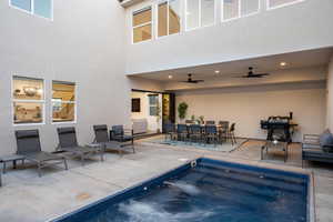 View of swimming pool featuring a ceiling fan, a patio area, outdoor dining area, area for grilling, and a pool