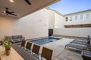 View of pool with a ceiling fan, a jacuzzi, an outdoor living space, and a patio