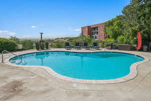 Community pool with a patio area AND CITY VIEWS.