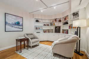 Sitting room featuring rail lighting and light wood finished floors