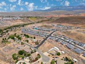 Aerial view of property and surrounding area with a mountainous background and nearby suburban area