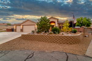 View of front of property with concrete driveway, stucco siding, a tiled roof, and an attached garage