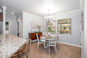Dining area with ornamental molding and a chandelier