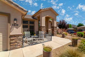 View of exterior entry with stone siding, stucco siding, and a tile roof