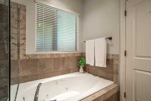 Primary bathroom featuring a tub with jets