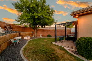 Yard at dusk featuring a patio area, a fenced backyard, and a pergola